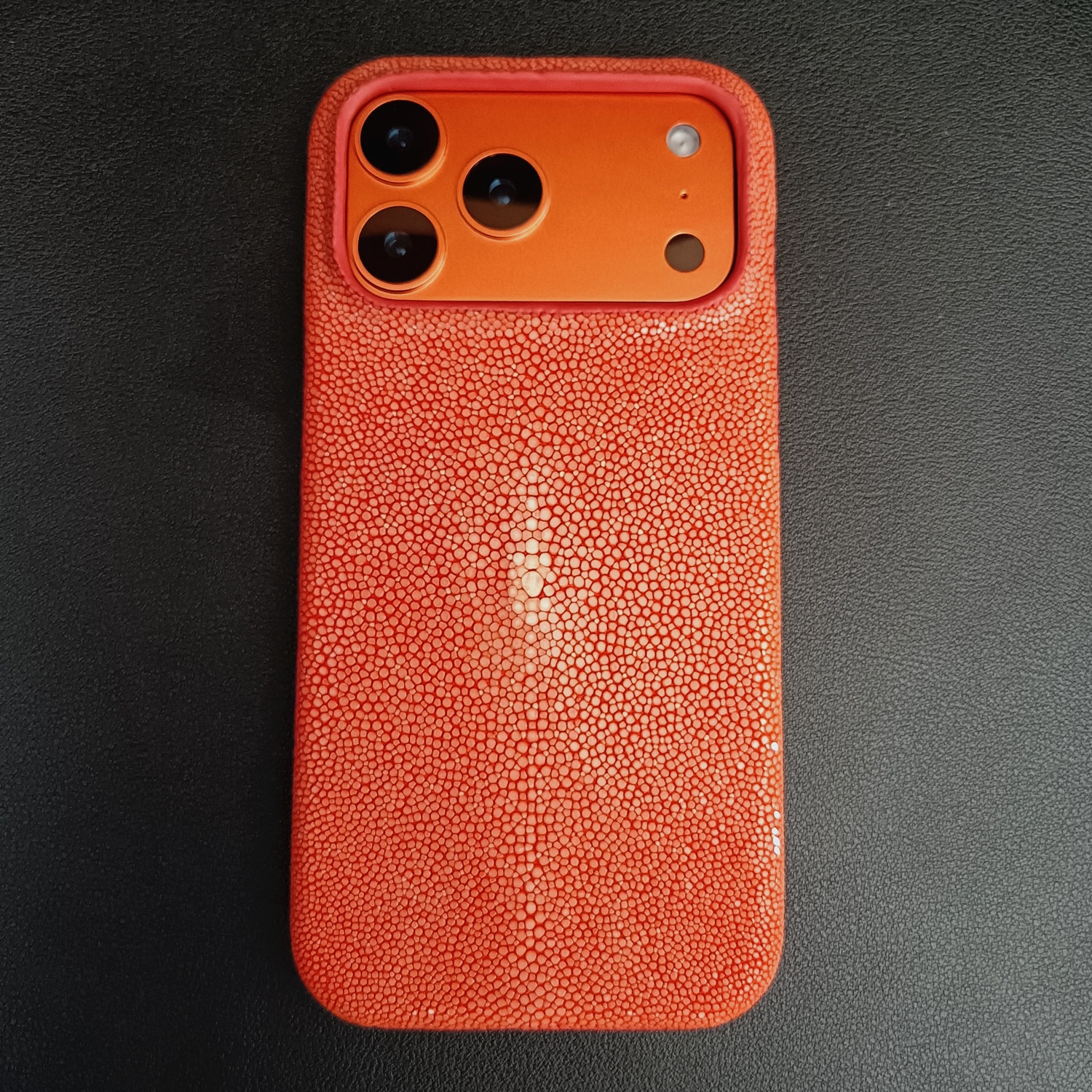 スティングレイ（エイ革）オレンジをiPhone 17 Proに装着したところ（メーカー実物写真）